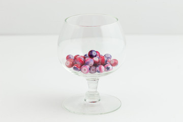 red white and blue jewelry beads in a small clear glass goblet