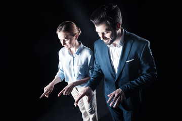 Professional tech. Nice delighted joyful businesspeople standing together and touching virtual objects while using virtual technology