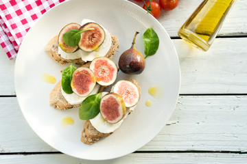 fresh ripe sliced fig on toast bread mozzarella cheese Italian crostini dish light lunch starter