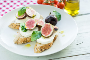 fresh ripe sliced fig on toast bread mozzarella cheese Italian crostini dish light lunch starter