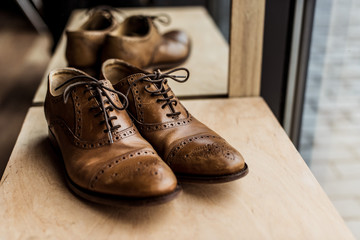 modern brown male shoes at showcase in shop