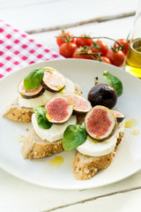 fresh ripe sliced fig on toast bread mozzarella cheese Italian crostini dish light lunch starter