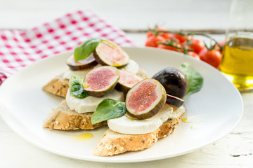 fresh ripe sliced fig on toast bread mozzarella cheese Italian crostini dish light lunch starter
