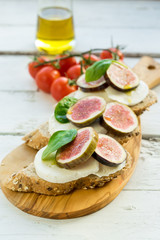fresh ripe sliced fig on toast bread mozzarella cheese Italian crostini dish light lunch starter