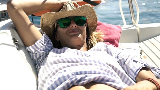Young woman relaxing, sleeping while sailing boat on sea, super slow motion 120fps
