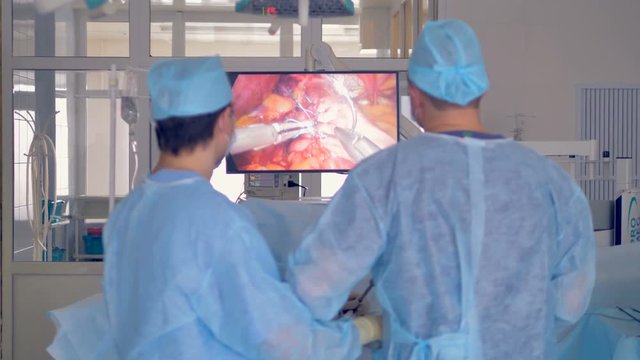 Surgeons stich internal human organs during laparoscopy.  