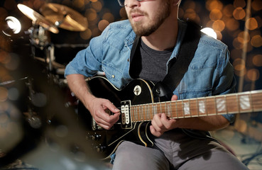 close up of musician playing guitar at studio