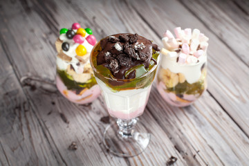 Desserts with sweets in glasses on a gray wooden background