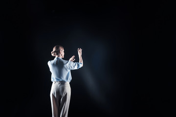 Newest technology. Nice pleasant young woman turning her back to you and looking in front of her while being in virtual reality