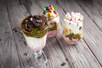 Desserts with sweets in glasses on a gray wooden background