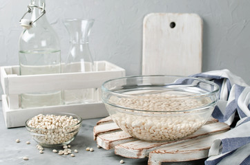 White beans soaked in water in a glass bowl