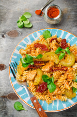 Fusilli with chicken, zucchini, sun-dried tomatoes and baby-salad