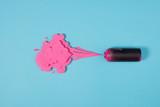 top view of spray paint in can and paper splashes isolated on blue