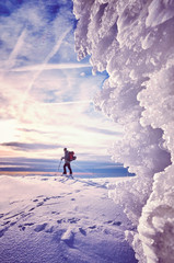 Fototapeta Ice formations with cross-country skier silhouette in distance at sunset, color toned picture, Karkonosze National Park, Poland. obraz
