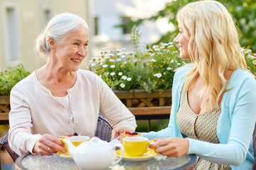 daughter with senior mother drinking tea at cafe