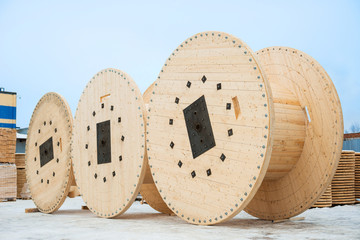 Large empty wooden coils. The new cable drums at the industrial area. Outdoors