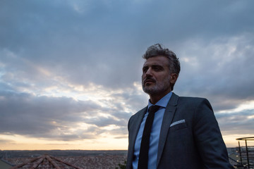 Mature businessman standing in a hotel balcony.