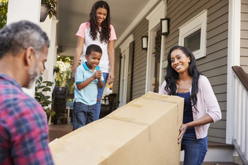 Family Carrying Big Box Purchase Into House