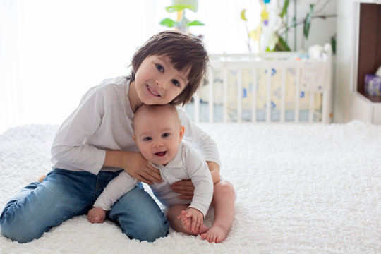 Little toddler boy, playing with his little brother at home