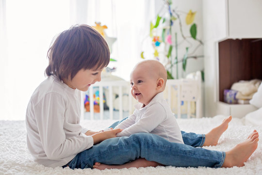 Little toddler boy, playing with his little brother at home