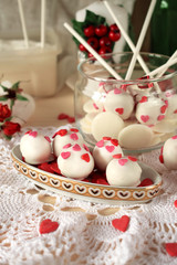 Fototapeta na wymiar White chocolate sweets and cake pops decorated with little confectionery hearts
