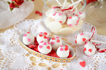 White chocolate sweets and cake pops decorated with little confectionery hearts