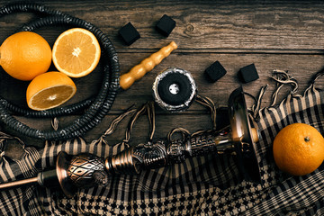 Dismantled parts of hookah on a wooden background with orange fr