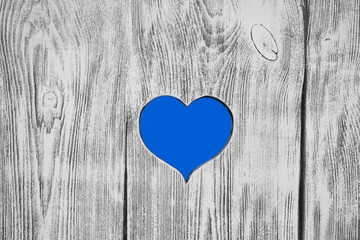 blue heart carved in a wooden board. Background.