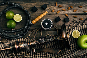 Dismantled parts of hookah on a wooden background with lime frui