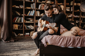 beautiful sexy girl and her boyfriend playing guitar