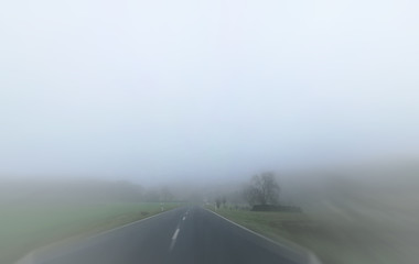 Nebel im Straßenverkehr über einer Landschaft mit Landstraße