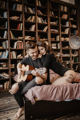 Fototapeta na wymiar beautiful sexy girl and her boyfriend playing guitar