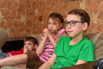 Caucasian boy laying on bed watching tv