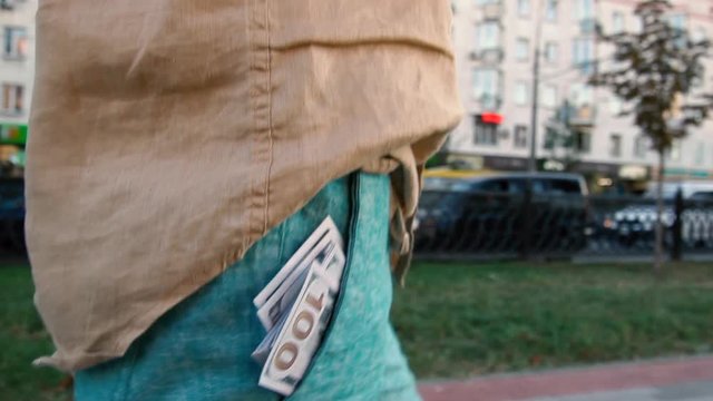 dollar bills sticking out of the pocket of a man.