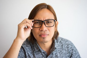 Focused Asian Man Staring Through Glasses