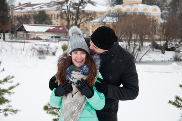 Happy family couple walking in the afternoon in a winter park.