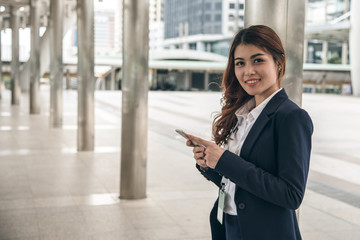 Fototapeta premium Asian business woman is holding and using phone.