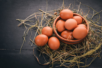 Chicken raw brown eggs. On a wooden background. Top view. Copy space.