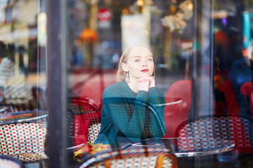 Obraz premium Young elegant woman drinking coffee in cafe in Paris, France