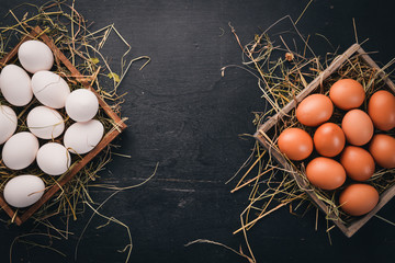 Chicken raw eggs in a wooden basket. On a wooden background. Top view. Copy space.