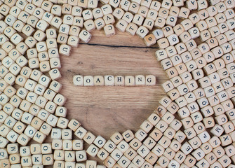 Coaching Buchstaben Würfel auf einem Holzbrett
