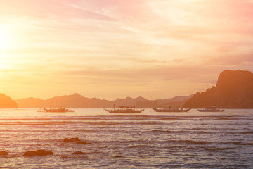 Bangka boats view at beautiful sunset on El Nido bay, Palawan island, Philippines