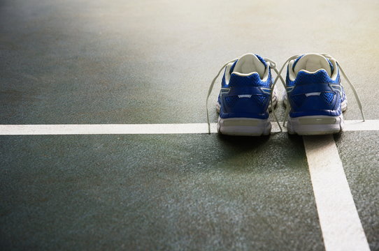 pair of sport shoes for running or active exercise for health on the dark green floor gymnasium with white line background