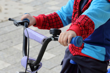 A boy on his bicycle, holding steering wheel