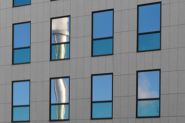 reflet de chemin&eacute;e industrielle sur fen&ecirc;tres d'immeuble moderne