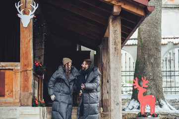 Classy groom and his gorgeous bride pose outside in winter coats 