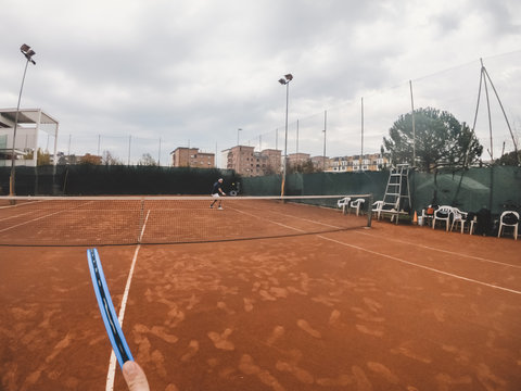 Point of view of tennis player during a match on a clay court