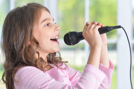 Beautiful little girl with microphone 