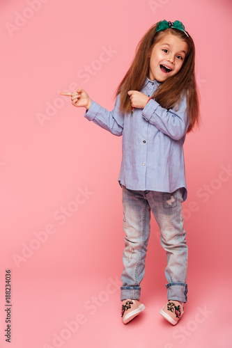 Full Length Picture Of Funny Little Girl Gesturing Pointing