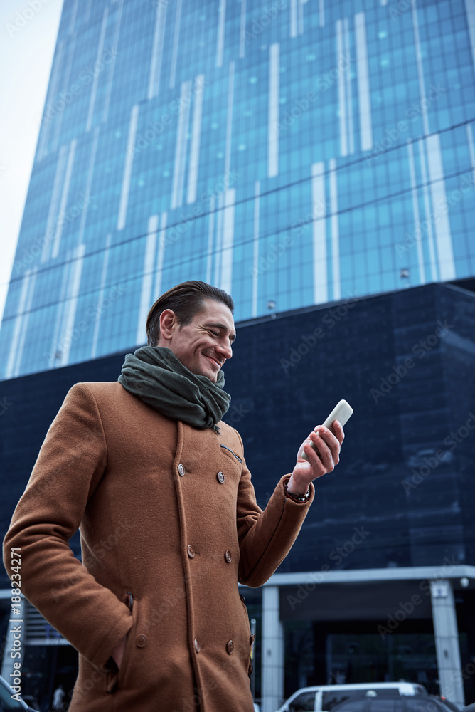 Aufkleber side view beaming man sending message by phone while walking on street. gadget concept